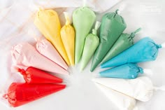 six different colored cones are arranged in a circle on a white tablecloth with a checkered cloth behind them