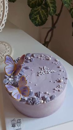 a cake with purple frosting and butterflies on it