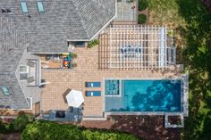 an aerial view of a house with a swimming pool and patio area in the foreground