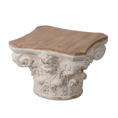 a white and wooden table with carvings on the top, sitting against a white background