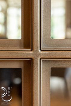 four square glass panels on the side of a door that is brown and has white trim