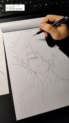 someone is drawing on paper with a pen