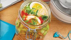 a jar filled with food sitting on top of a wooden table