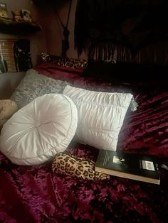 there is a stuffed animal laying on the bed next to some pillows and a book