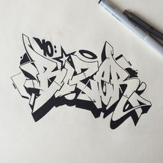 graffiti written in black ink on white paper next to a ballpoint pen and marker