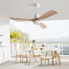 a ceiling fan that is on the side of a wall near a table and chairs