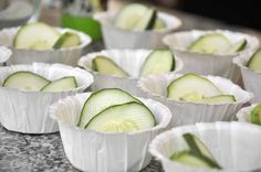 several cups with cucumbers in them sitting on a counter