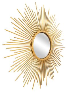 a gold sun mirror on a white wall