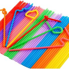 many different colored straws and scissors on a white background