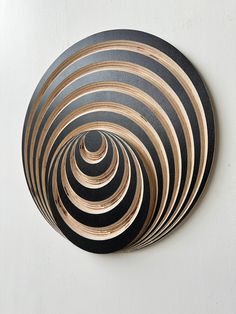 a black and gold circular object hanging on the side of a wall with white walls