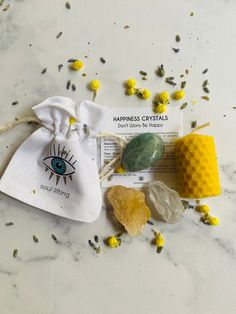 three different types of crystals are on the table next to a bag with yellow flowers