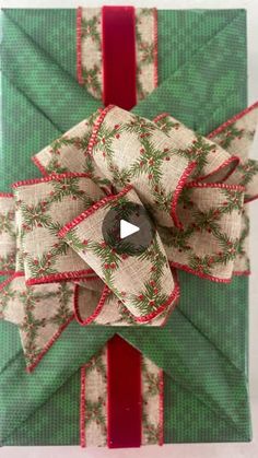 an ornament wrapped in green and red paper with a bow on it's side