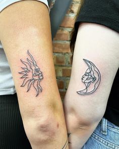 two people with matching tattoos on their arms, one is holding the other's arm