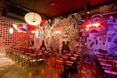 an empty restaurant with tables and chairs in front of a large mural on the wall