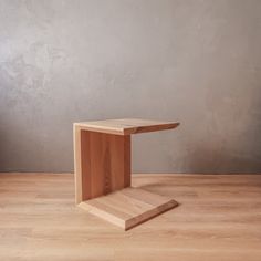 a wooden table sitting on top of a hard wood floor next to a gray wall