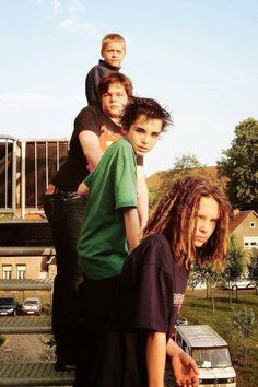 a group of young men standing next to each other on top of a car trunk