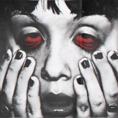 a woman with red eyes holding her hands to her face