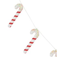 two candy canes are hanging from a string with sprinkles on them