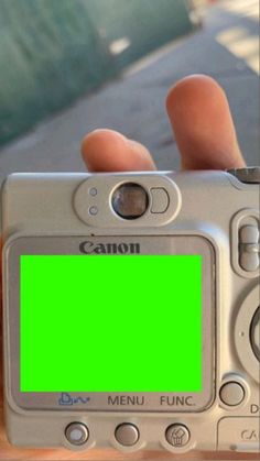 a person holding up a camera with a green screen on it's front side