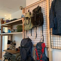 several backpacks are hanging on the wall next to each other in a room with shelves