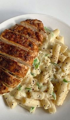 a white plate topped with pasta and meat