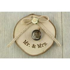 two wedding rings tied to a wooden slice with the word mr and mrs on it