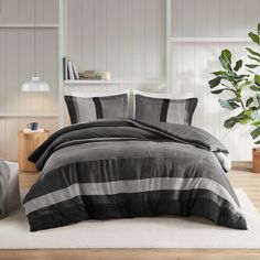 a bed with grey and black striped comforter