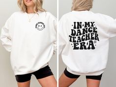 Step into your dance teacher era in the coziest and most stylish way with our 'In My Dance Teacher Era' sweatshirt! Made from ultra-soft, high-quality fabric, it's perfect for staying warm during long hours in the studio or while cheering on your students at performances. The playful retro design adds a fun touch that celebrates your role as a dedicated dance educator. This sweatshirt is not only great for layering over your dance gear, but it's also the perfect gift for the dance teacher in you Long Sleeve Letter Print Sweatshirt For Dance Class, Relaxed Fit Letter Print Sweatshirt For Dance Class, Relaxed Fit Sweatshirt With Letter Print For Dance Class, Cotton Long Sleeve Sweatshirt For Dance Class, Letter Print Sweatshirt For Dance Class In Fall, Casual Graphic Print Sweatshirt For Dance Class, Casual Tops For Dance Class In Fall, Casual Fall Tops For Dance Class, Relaxed Fit Long Sleeve Tops For Dance Class