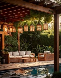 an outdoor living area next to a swimming pool with wicker furniture and hanging lights