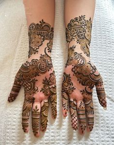 two hands with henna designs on them