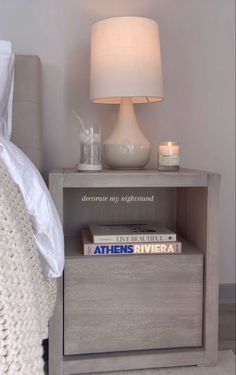 a nightstand with books and a lamp on it