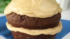 a chocolate cupcake with white frosting on a blue napkin