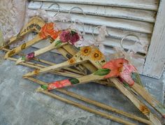 four wooden clothes pins with floral designs on them sitting next to a window sill