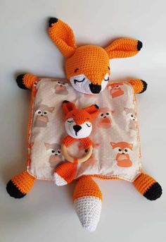 an orange stuffed animal laying on top of a blanket