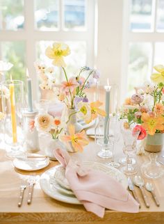 the table is set with flowers and candles