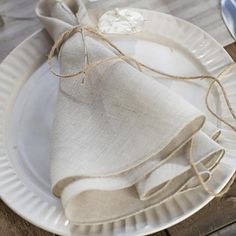 a white plate topped with a napkin and two silver spoons on top of it