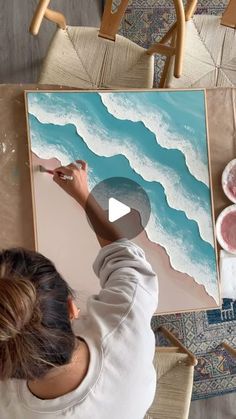 a woman is working on an art project with acrylic paint and watercolors