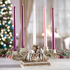 a group of lit candles sitting on top of a table next to a christmas tree