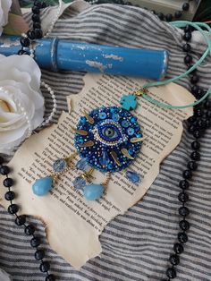 a necklace is laying on top of an old book with beads and flowers next to it