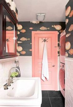 a bathroom with a sink, mirror and pink door