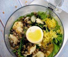 a food processor filled with vegetables and an egg