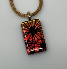 a necklace with an orange and black design on it