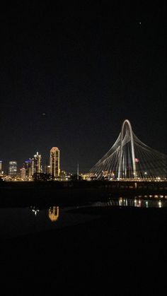 the city is lit up at night with its lights on and reflecting in the water