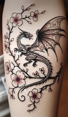 a woman's thigh with a dragon tattoo on it and flowers in the background