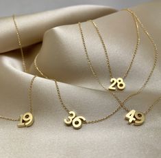 "Tiny gold number charms on a delicate 14k gold-filled chain.  This necklace is perfect for everyday wear, whether you want to showcase your lucky numbers or proudly display your favorite football team number. The necklace itself is designed with a length of 16\", making it an ideal piece for layering or wearing on its own. At my shop, I offer customization options to ensure the perfect fit for your bracelets or necklaces. Simply leave me a note, and I'll happily adjust the length according to y Number Jewelry, Number Gifts, Locket Design, Delicate Gold Necklace, Customizable Jewelry, Number Necklace, 18k Gold Necklace, Tarnished Jewelry, Stacked Necklaces