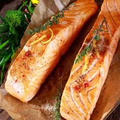 two salmon fillets sitting on top of a wooden cutting board