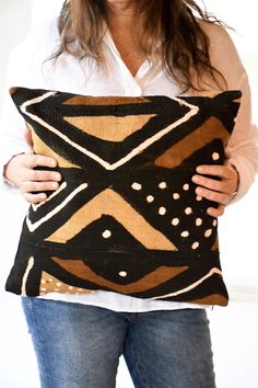 a woman holding a decorative pillow in her hands