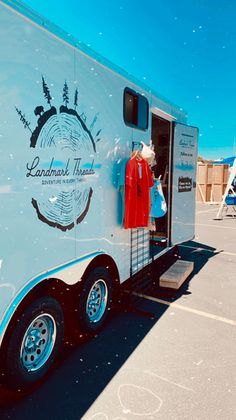 an ice cream truck with mannequins on the side and clothes hanging out to dry