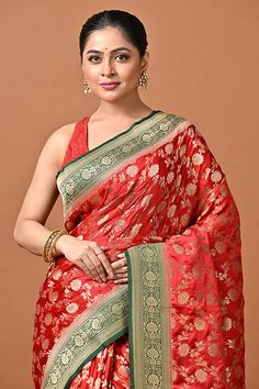 This Red color blended silk saree is crafted with golden zari weaved floral jaal works all over the body. Contrast green color pallu and the border is crafted with golden zari weaved designer work all along, which adds an highlight to the saree. Blouse piece attached. This Banaras manufactured silk saree is extremely soft and comfortable, mixed with beautiful colors & design pattern, making it a perfect wear for you at any occasion. Buy this red color contrast soft banarasi gajji silk saree Gajji Silk Saree, Banarasi Silk Saree