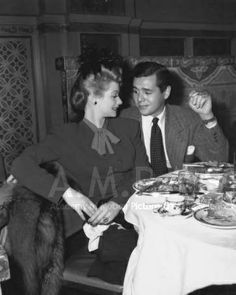 an old black and white photo of two people sitting at a table